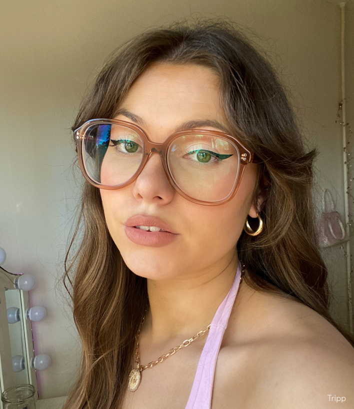 A woman wearing oversized blue light glasses